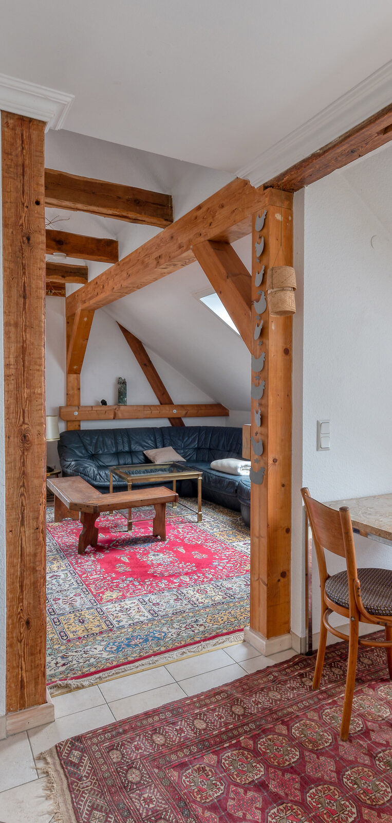 Adlerwohnung — Wohnbereich mit sichtbaren Holzbalken
